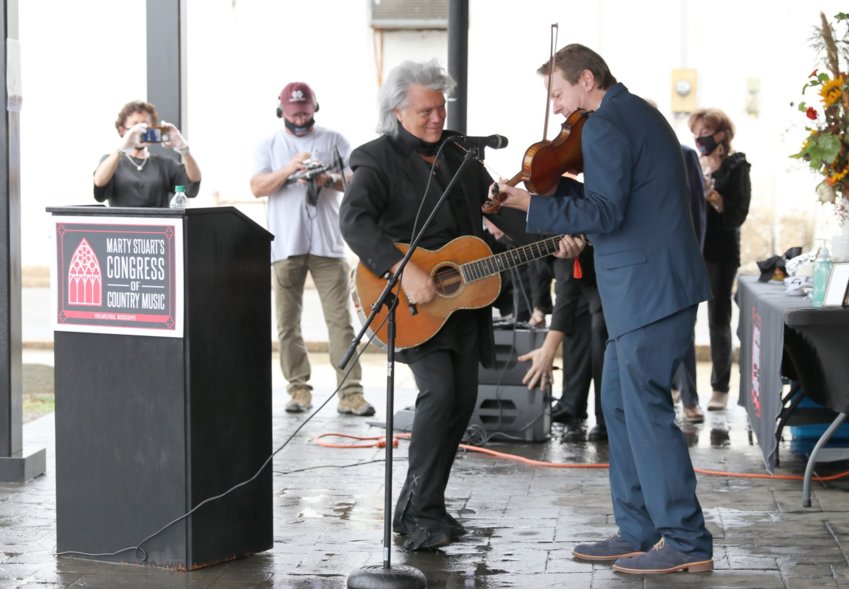 Neshoba County’s own Marty Stuart jams out with bluegrass musician Stuart Duncan, right, last Wednesday during a topping off ceremony for the Marty Stuart Congress of Country Music downtown. The event was curtailed by the coronavirus pandemic.
